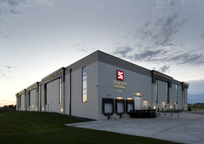 Modern distribution center and loading docks exterior with exterior lighting at dusk