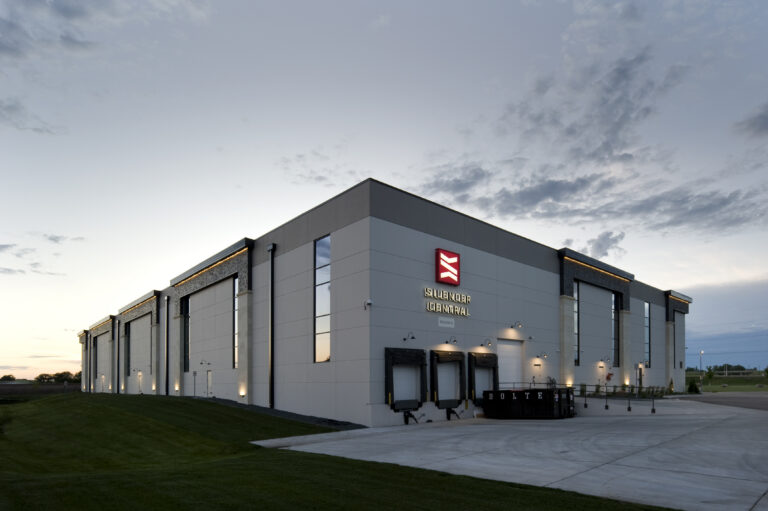 Modern distribution center and loading docks exterior with exterior lighting at dusk