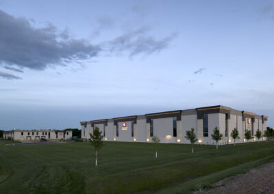 Modern distribution center exterior with exterior lighting at dusk